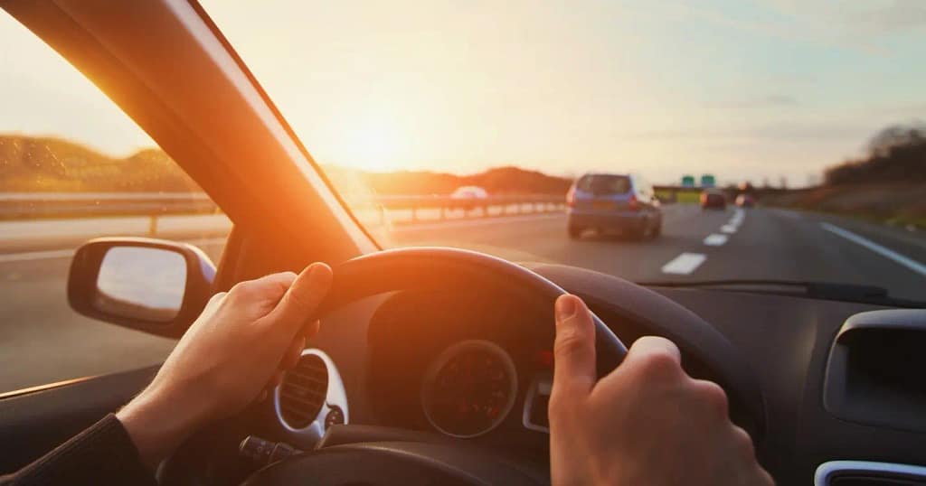 Une personne qui emprinte une bretelle d'une voie rapide avec le soleil qui se couche