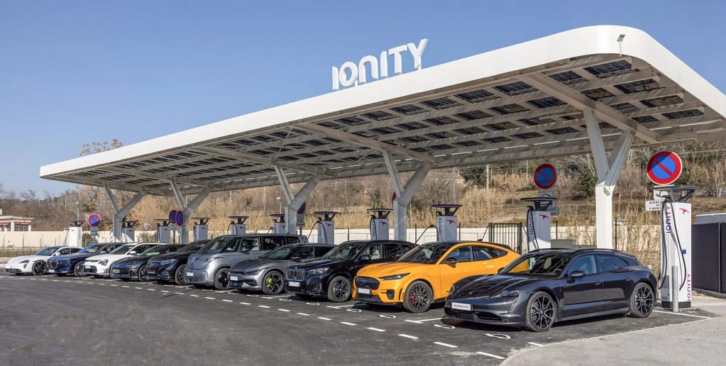 Une station de recharge Ionity en pleine journée avec de nombreux véhicules en train de recharger.