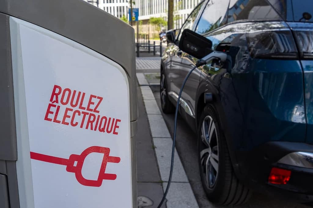 Une voiture electrique près d'une borne de recharge