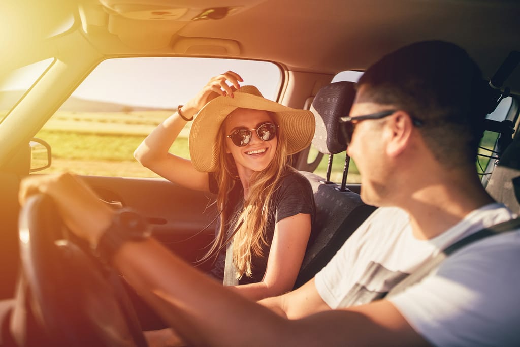 Un jeune couple part en vacances en été en voiture électrique